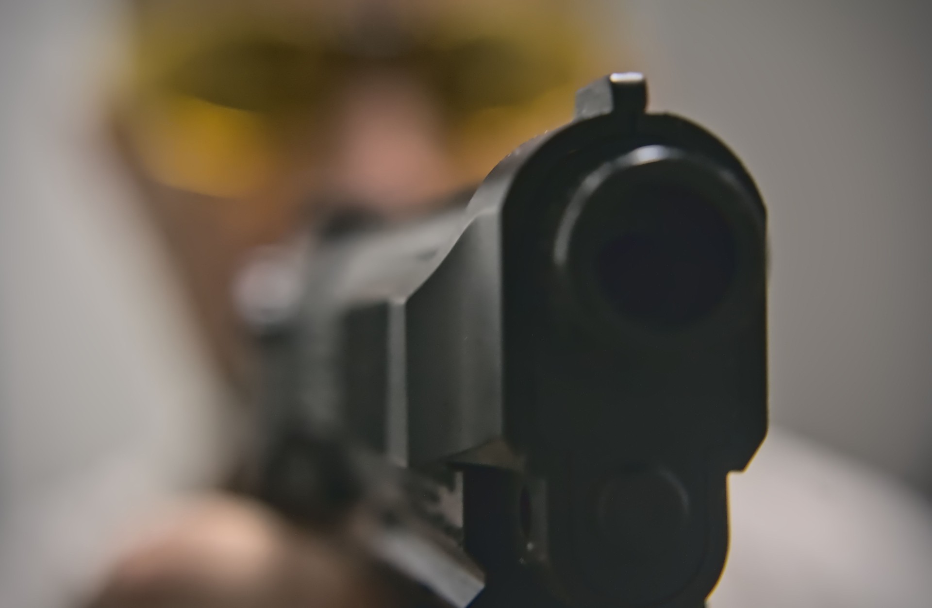 Man aiming target with a gun macro view