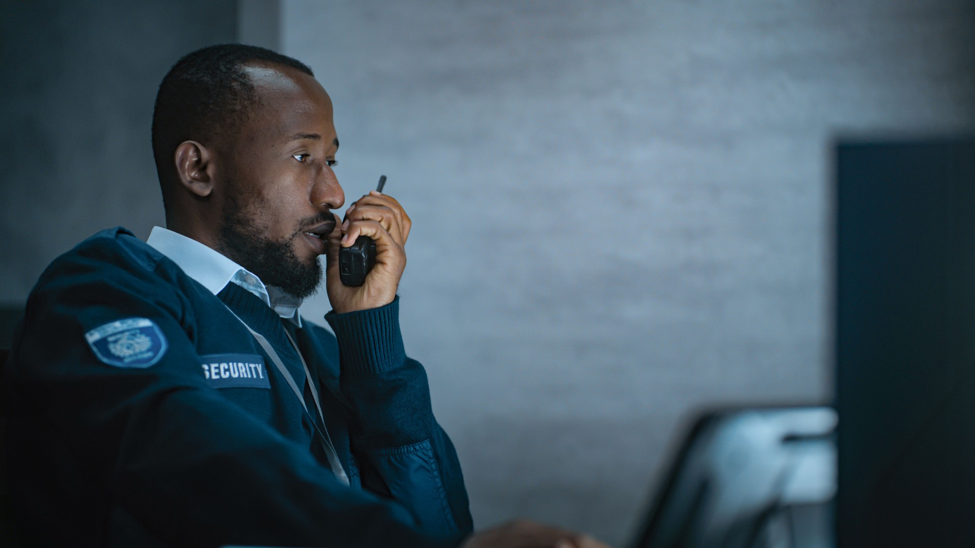 African American security officer works in monitoring center during night shift African American security officer works in monitoring center during night shift